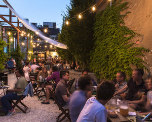 People sitting in yard at Gowanus location eating and drinking